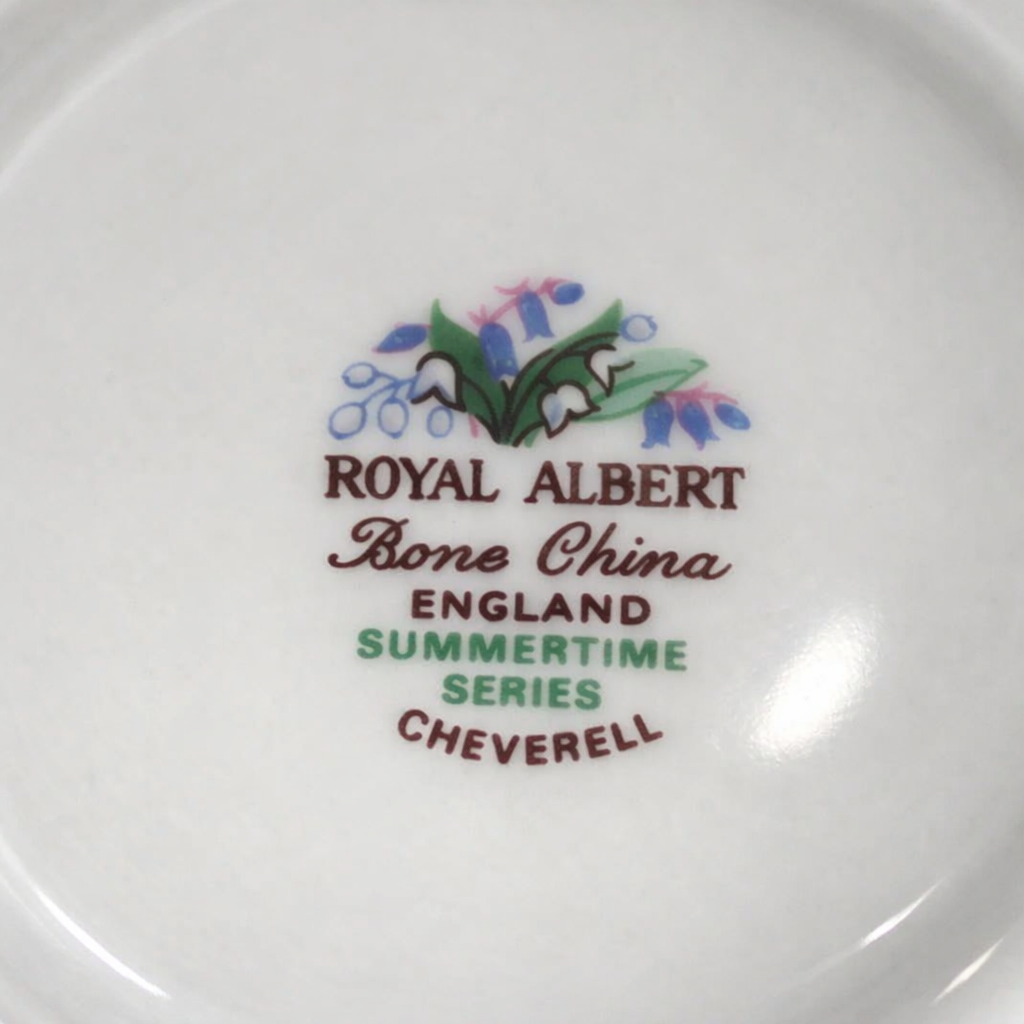 Tazza con piattino in Bone China – Royal Albert “Summertime – Cheverell” Raffinata tazza con piattino in fine Bone China inglese, prodotta dalla rinomata manifattura Royal Albert. Il decoro floreale policromo, appartenente alla serie “Summertime” nel modello “Cheverell”, raffigura un delicato bouquet di mughetti e campanule nei toni del verde, azzurro e lilla, impreziosito da sottili dettagli rosati. La forma elegante, con profilo leggermente mosso, ansa sagomata e bordo rifinito da una sottile filettatura in oro, esprime il tipico gusto romantico e senza tempo della tradizione inglese. In ottime condizioni di conservazione, è un pezzo ideale per collezionisti o per aggiungere un tocco di charme a una tavola o vetrina.
