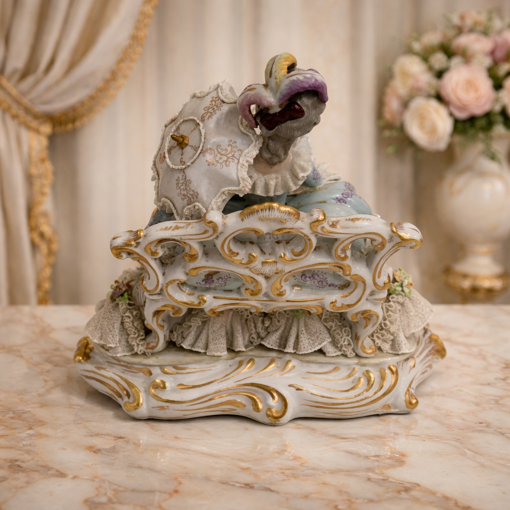 Scultura in porcellana policroma finemente modellata, raffigurante dama in abiti settecenteschi seduta su elegante seduta rocaille. La figura, di gusto rococò, è impreziosita da ricchi decori floreali applicati, delicati motivi dipinti e abbondanti dorature, con accurata resa dei merletti, dei panneggi e dell’acconciatura. La base sagomata, mossa e dorata, completa armoniosamente la composizione. Produzione Capodimonte, Italia, XX secolo, come da marchio al verso; oggetto decorativo di pregio, in buono stato di conservazione.