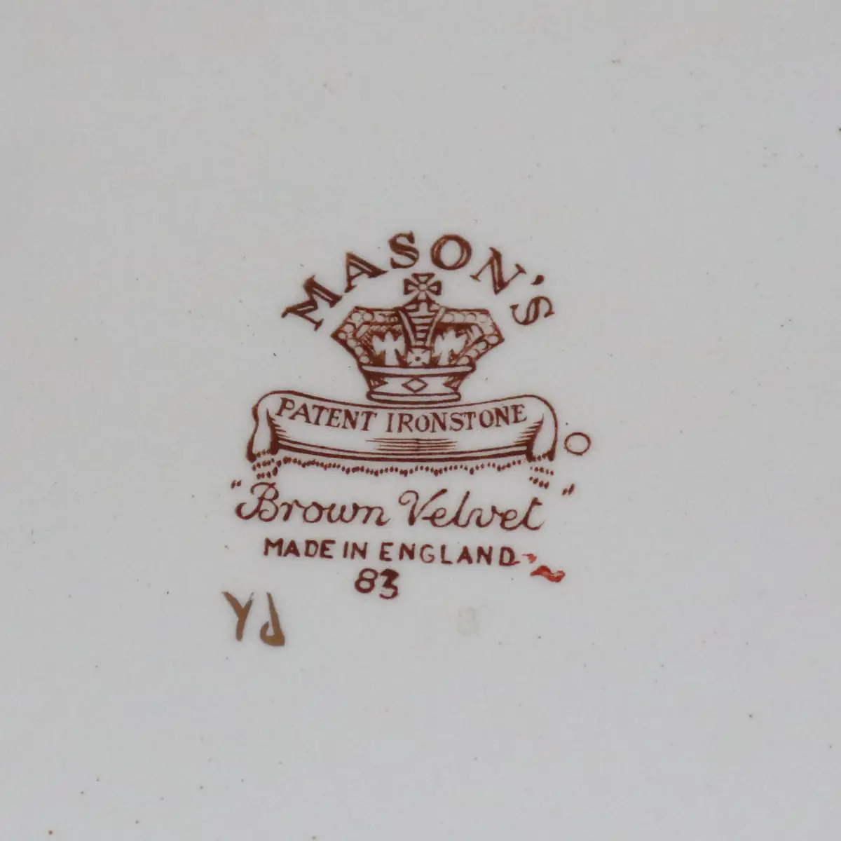 Piatto in ironstone inglese Mason’s, decoro “Velvet Brawn”, con ricche volute brune e fiori policromi in tonalità rosso, giallo e verde su fondo avorio, bordo profilato in oro. Manifattura Staffordshire, prima metà del XX secolo. In buono stato di conservazione.