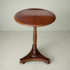 Elegante tavolino gueridon da centro della prima metà del XIX secolo, realizzato in legno massello e caratterizzato da una linea sobria e armoniosa riconducibile al gusto Impero / Restaurazione. Il piano circolare con bordo sagomato è sostenuto da un fusto centrale tornito, poggiante su una solida base trilobata con piedi sagomati. Il mobile conserva una bella patina antica e si presenta in buone condizioni generali, con lievi segni del tempo coerenti con l’età. Un complemento raffinato e versatile, ideale come tavolino da salotto, tavolino da appoggio o porta lampada, adatto ad ambienti classici e collezioni di arredi d’epoca.