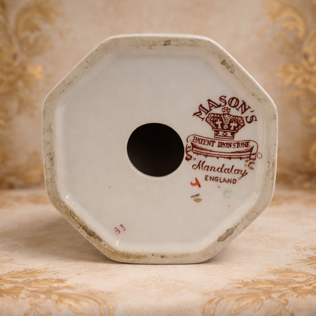 Portacandela in fine porcellana inglese Mason’s, linea Mandalay, con elegante forma slanciata e base poligonale. Decorazione floreale policroma con elementi in blu cobalto e ricche dorature. Marchio al fondo “Mason’s – Patent Ironstone – Mandalay – England”. Produzione del XX secolo. Oggetto decorativo di gusto classico, in buono stato di conservazione.