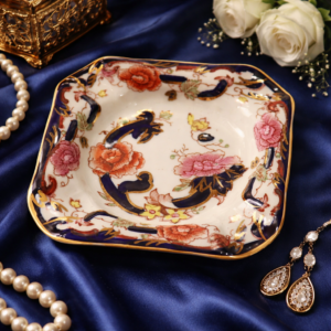 Dish o comunemente svuota tasche quadrata in porcellana inglese Mason’s Ironstone – Mandalay, decorazione floreale policroma con motivi blu cobalto e ricchi profili in oro su fondo avorio. Produzione della prima metà del XX secolo. In buono stato di conservazione, eleganti elementi decorativi e da collezione.