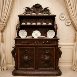 Credenza–piattaia di fine XIX secolo in noce massello finemente intagliato, composta da base a due ante e alzata con ripiani a giorno. Ricca decorazione a motivi floreali, cornucopie, frutti e volatili, con imponente cimiero scolpito. Mobile di grande eleganza e presenza, tipico del gusto storicista di ispirazione rinascimentale, con bella patina originale.
