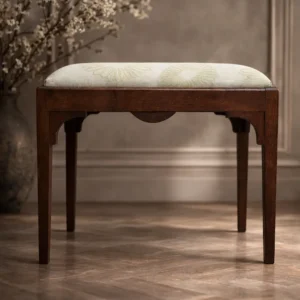 Elegante panchetta neoclassica, fine XVIII – inizi XIX secolo, in legno massello. Caratterizzata da linee sobrie, fasce sagomate e gambe rastremate, presenta un sedile imbottito rivestito in tessuto chiaro a motivi floreali, rifacimento successivo ma coerente. Struttura solida, bella patina originale e ottimo stato di conservazione. Mobile raffinato e versatile.