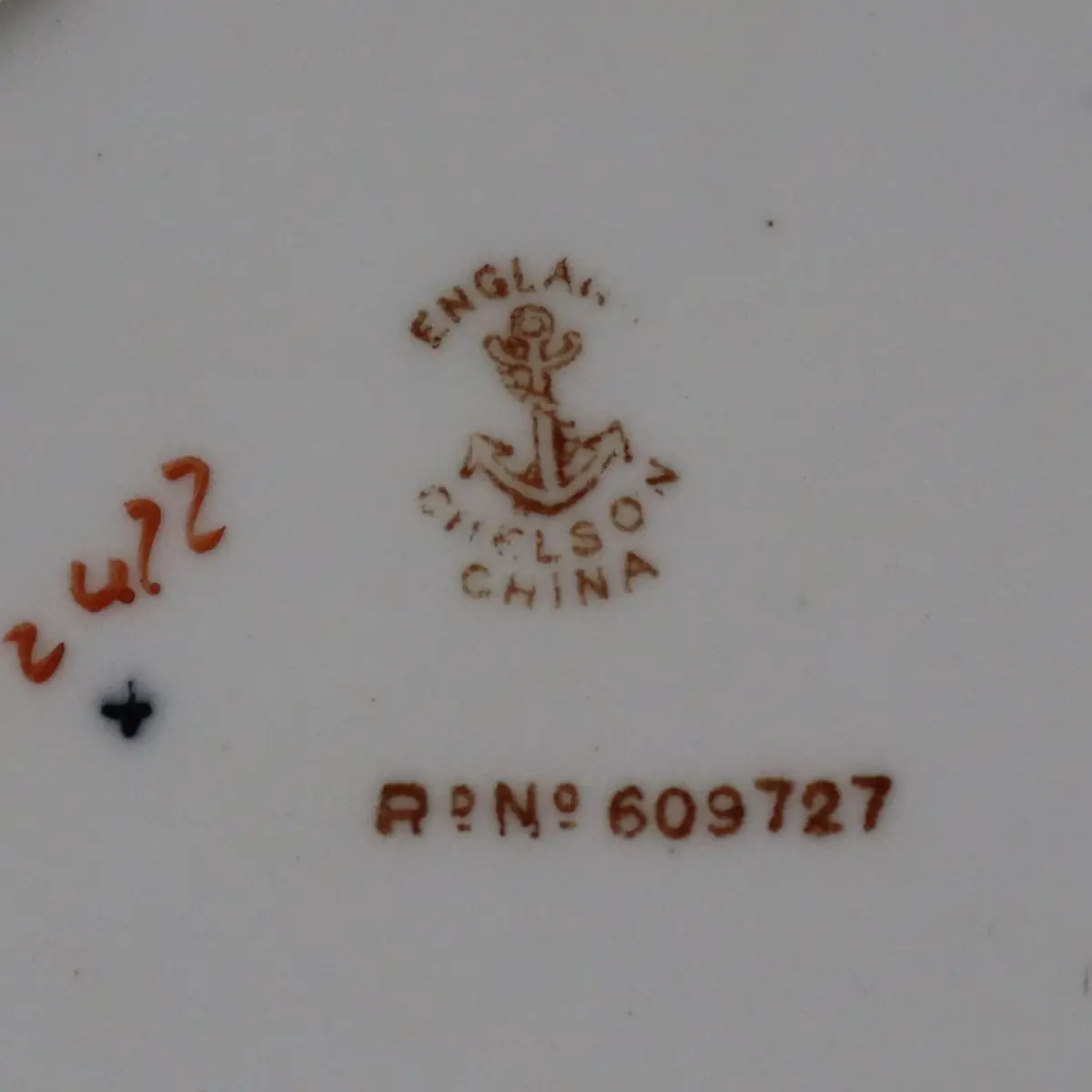Piatto in porcellana , numero di registrazione R° No. 609727, riconducibile alla produzione britannica del 1886., decorato in policromia con riserve a soggetto orientale stilizzato alternate a motivi floreali e cartigli, su fondo bianco. Bordo sagomato con campiture in rosso ferro e filettature dorate. Marca al verso “England – Wilson China” con numero di registrazione. In buone condizioni generali, con lievi segni d’uso compatibili con l’età.