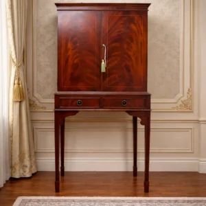 Elegante mobile bar edoardiano di notevole qualità estetica e costruttiva, adatto sia a contesti classici sia ad ambienti contemporanei come pezzo d’accento di grande fascino. Mobile bar in legno pregiato, manifattura inglese edoardiana (inizio XX secolo). Corpo superiore a due ante con impiallacciatura in mogano fiammato e filettature, su base con due cassetti e gambe alte scanalate. Interni con ripiani in vetro e fondo a specchio. Ferramenta originale in ottone. In buono stato di conservazione, con bella patina.