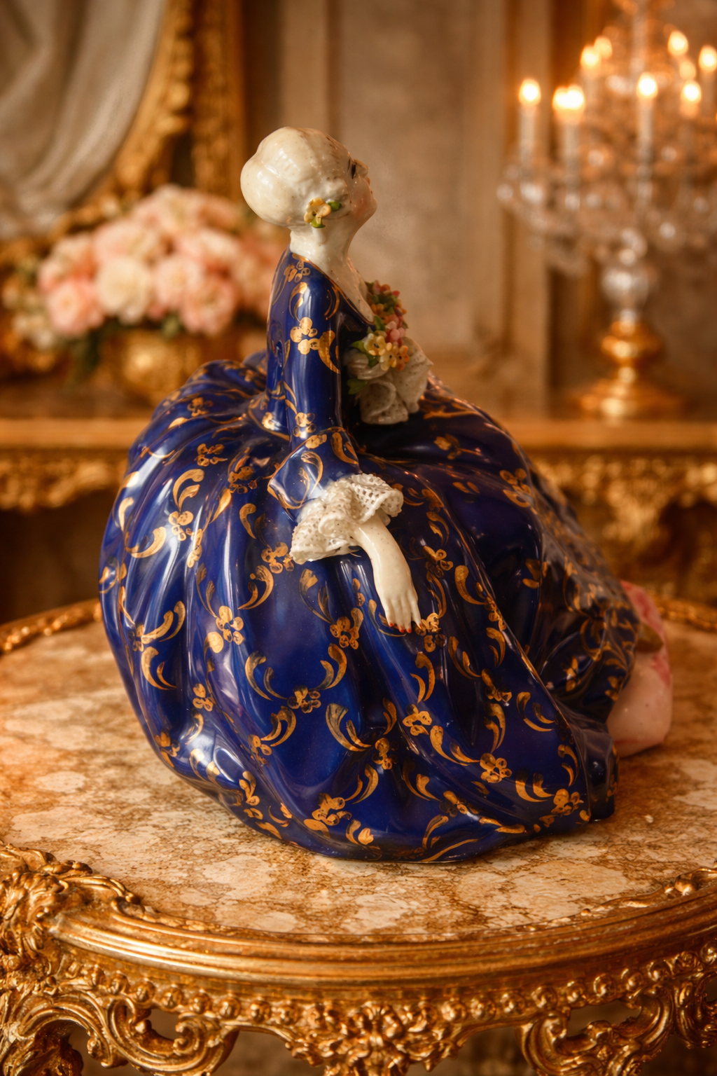 Raffinata statuina in porcellana policroma di manifattura Fabris, raffigurante elegante dama in abiti settecenteschi seduta, con ricco abito blu cobalto impreziosito da dorature a foglia e motivi ornamentali di gusto rococò. Il busto è finemente modellato, con volto delicato, incarnato luminoso e bouquet floreale applicato sul petto; presenti dettagli a rilievo e accurata smaltatura. La base sagomata completa la composizione con armonia ed equilibrio. Manifattura: Fabris Epoca: XX secolo Stato di conservazione: ottimo.