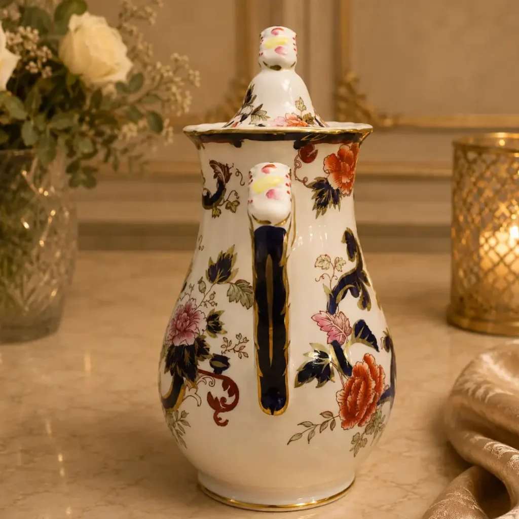 Caffettiera con coperchio in ironstone inglese Mason’s, decorazione policroma floreale con motivi orientalizzanti e ricche riserve in blu cobalto e oro. Corpo slanciato, beccuccio arcuato e manico sagomato con profili dorati. Marchio al fondo: Mason’s Ironstone – Made in England – “Mandalay”. Produzione inglese, prima metà del XX secolo. In buono stato di conservazione.