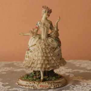 Porcellana Capodimonte Dama un capolavoro della collezione Fabris rara. Eseguita in porcellana lucida Policroma in sottosmalto. Una creazione splendida e raffinata per collezionisti esigenti. Le dimensioni ridotte di quest'opera la rendono ancor più preziosa e pregiata in quanto le proporzioni in statue di piccola dimensione sono ancora più difficili da realizzare. L'abito è realizzato con ornamenti di pizzo a balze nella parte centrale e finale della gonna e nella parte finale delle maniche non chè sul capellino. Il viso è finemente truccato. La statuina poggia su una base arricchita di fiori e altrettanto finemente decorata con firma sulla parte frontale. Le condizioni di quest'opera sono eccellenti. Misura: altezza cm. 21 LA PORCELLANA DI CAPODIMONTE E 'FAMOSA IN TUTTO IL MONDO E LEGATA ALLA STORIA DELLA DINASTIA BORBONICA. INFATTI, NEL 1743 FU FONDATA ALL'INTERNO DELLA REGGIA DI CAPODIMONTE, DIMORA DEL RE CARLO DI BORBONE E DI SUA MOGLIE ANNA DI SASSONIA, LA REAL FABBRICA DI CAPODIMONTE, LA CUI PRODUZIONE ARTISTICA NEL TEMPO DIVERRA 'PIU' PREGIATA E FAMOSA DI QUELLA FRANCESE E TEDESCA.