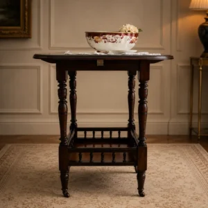 Elegante tavolino rotondo da salotto in stile vittoriano/edoardiano, realizzato in legno massello con bella venatura a vista e finitura calda. Il piano circolare presenta bordo sagomato, mentre la struttura è sostenuta da quattro gambe tornite affusolate, collegate inferiormente da una traversa con colonnine che ne aumenta la stabilità e il valore decorativo. Mobile di solida manifattura, databile  fine del XIX , in ottimo stato di conservazione. Ideale come tavolino da appoggio o complemento per ambienti classici ed eleganti.