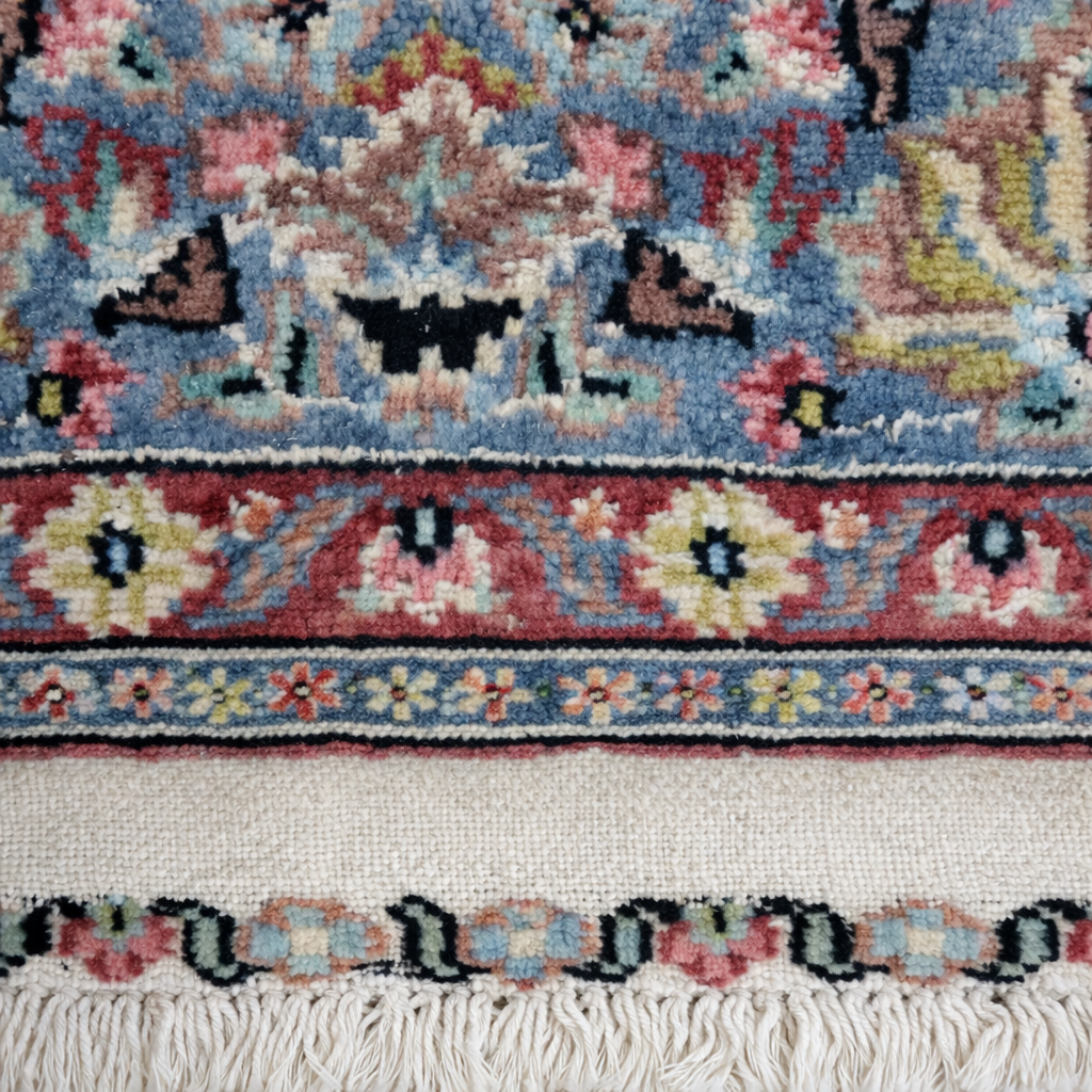 Elegante tappeto orientale di manifattura persiana, annodato a mano in lana su ordito in cotone, caratterizzato da un armonioso medaglione centrale su campo avorio riccamente decorato da motivi floreali e vegetali stilizzati. La composizione è racchiusa da una raffinata bordura a fondo azzurro-grigio con decori policromi coordinati. La palette cromatica, nei toni dell’avorio, rosa, azzurro, celeste e rosso mattone, dona luminosità e delicatezza all’insieme. Il tappeto si presenta in ottimo stato di conservazione, con vello compatto e colori ben conservati. Ideale per valorizzare salotti, studi o ambienti classici. Dimensioni: cm 190 x 130