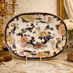 Piatto ovale Mason’s “Millennium Mandalay Dresser” – Edizione Limitata Raffinato piatto ovale in porcellana inglese prodotto da Mason’s (est. 1796) in occasione delle celebrazioni del Millennio. Appartiene alla serie commemorativa “The Mason’s Millennium Mandalay Dresser”, realizzata in tiratura limitata di soli 950 esemplari. La decorazione policroma riprende il celebre motivo “Mandalay”, con ricchi elementi floreali stilizzati, volute ornamentali di gusto orientale e intensa predominanza di blu cobalto, verde e rosso, impreziositi da dorature brillanti. Bordo profilato in oro. Marcato al verso con iscrizione ufficiale della serie e indicazione della tiratura limitata. Esemplare in eccellente stato di conservazione, ideale per collezionisti di ceramica inglese e per arredo di credenze o ambienti classici.