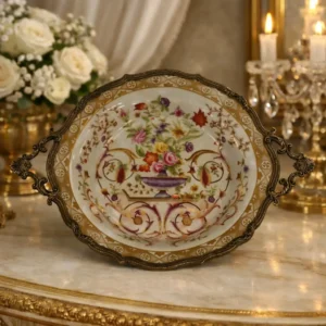 Centrotavola Wong Lee 1895, in porcellana finemente decorata a motivi floreali policromi con elegante vaso centrale. Montatura e manici laterali in metallo lavorato, bordo sagomato. Manifattura di gusto orientalista, raffinato oggetto d’epoca e da collezione.